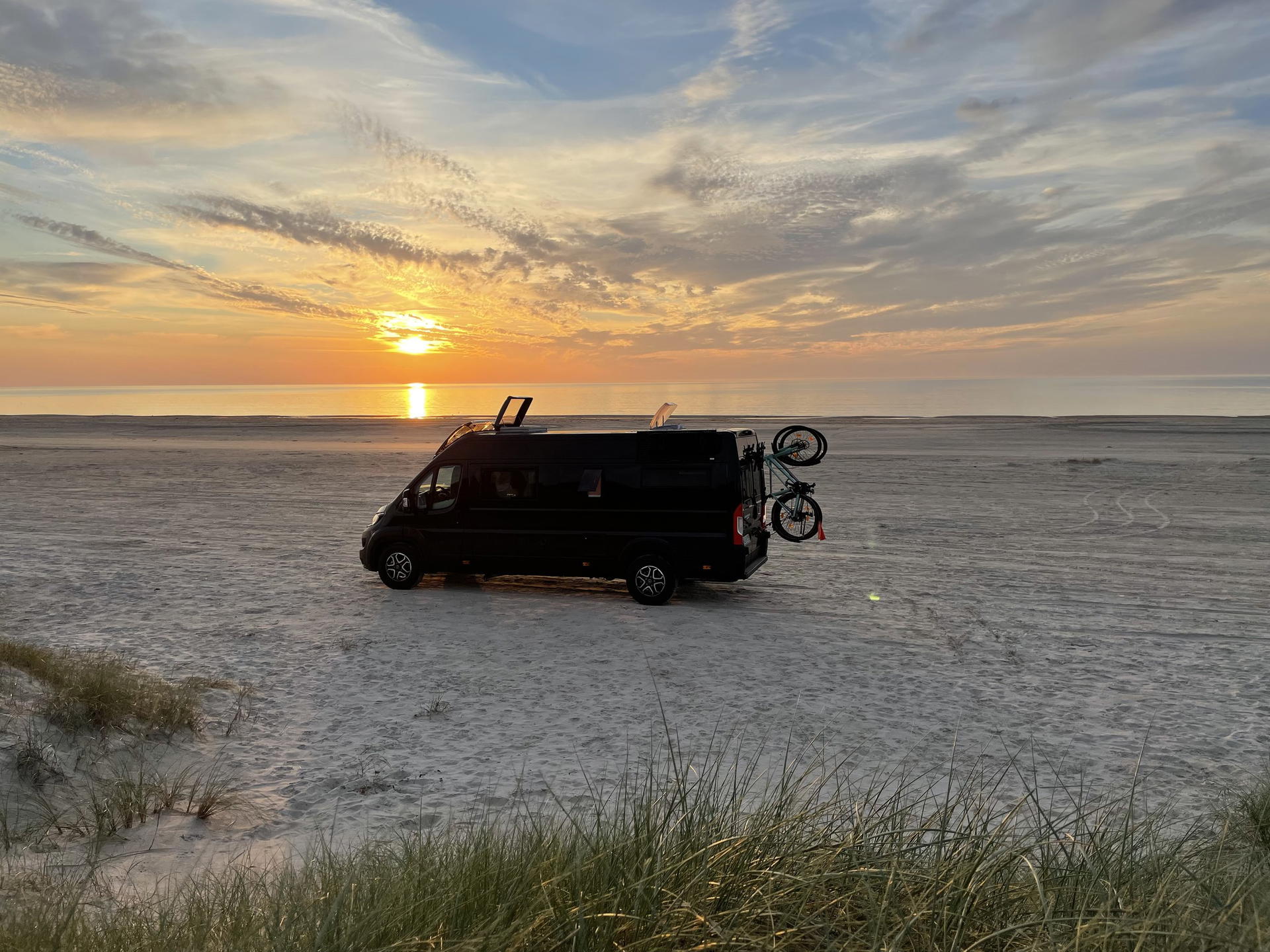 Our van Wilma parked at a Danish beach during sunrise